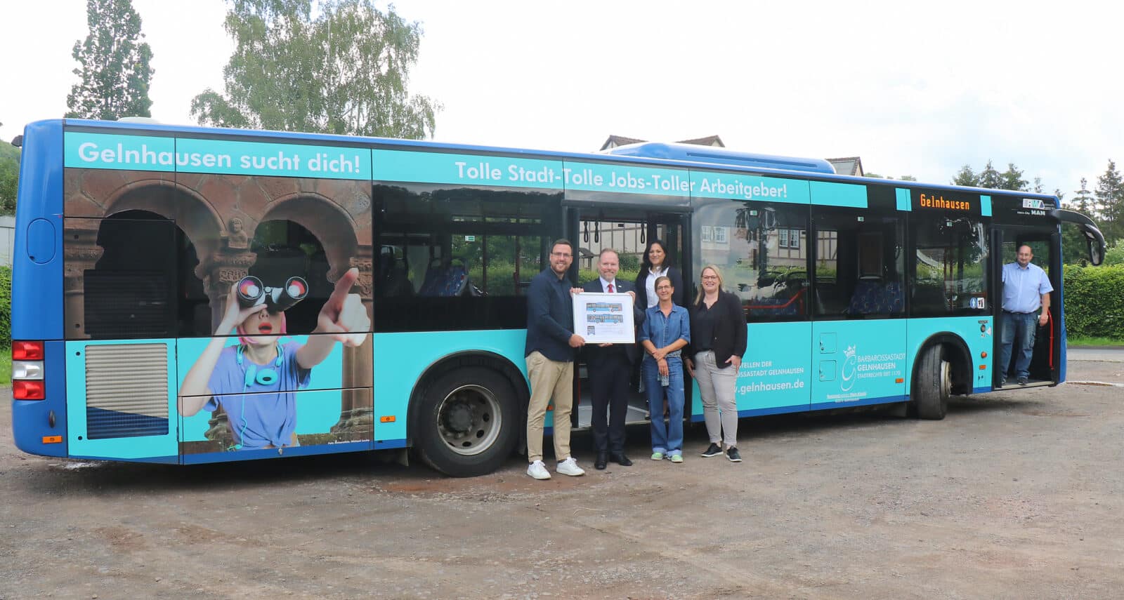 Gruppe von Menschen steht vor einem blauen Bus