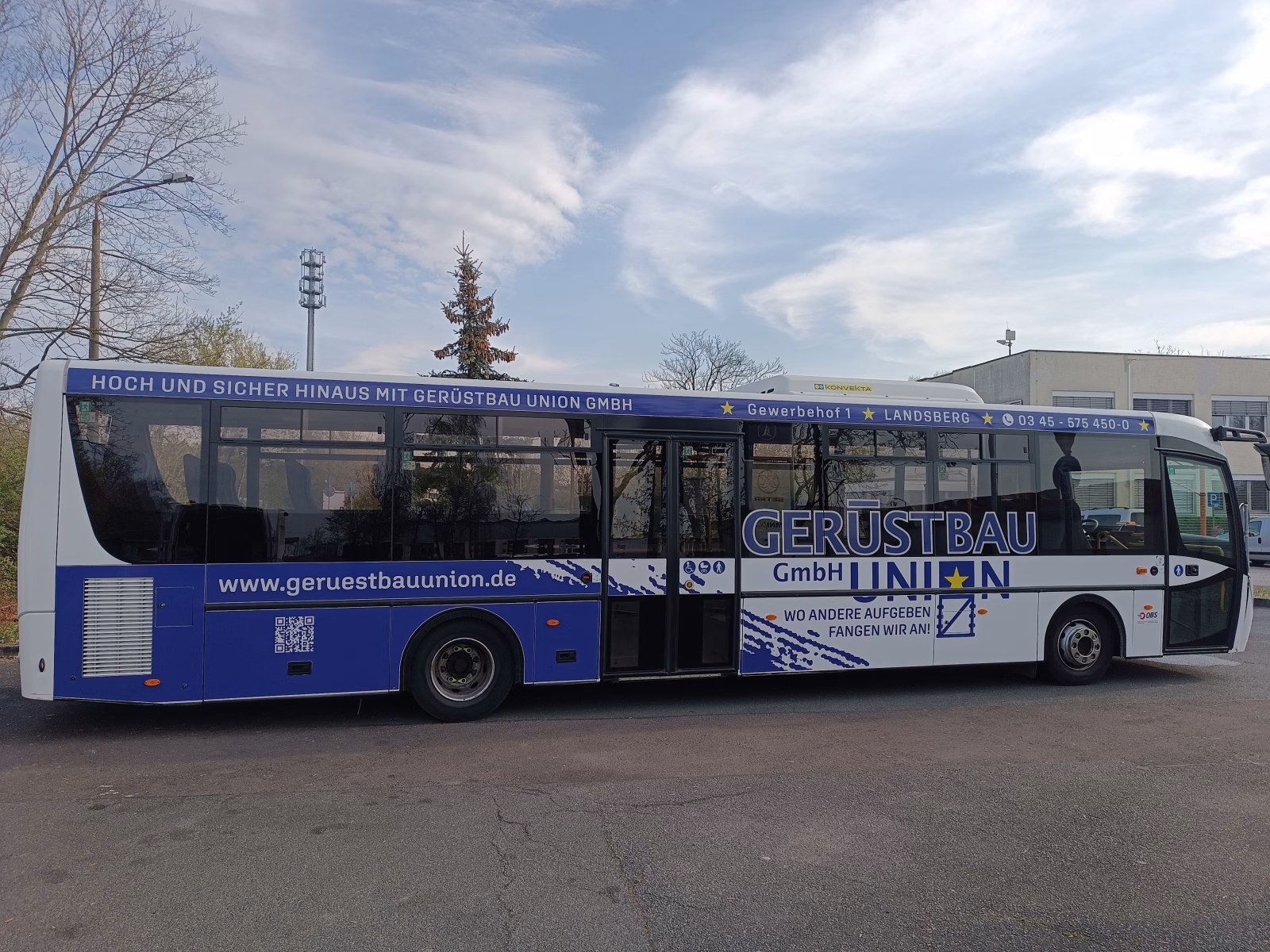 Einstiegsseite eines blauen Busses der Gerüstbauunion