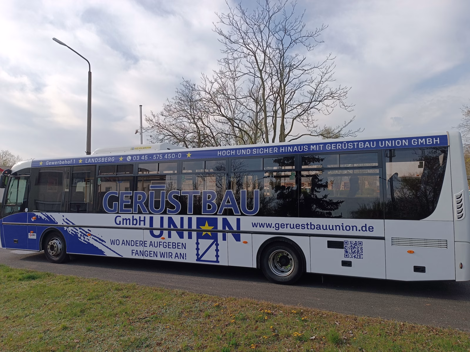 Außenseite eines blauen Busses, der für die Gerüstbauunion wirbt