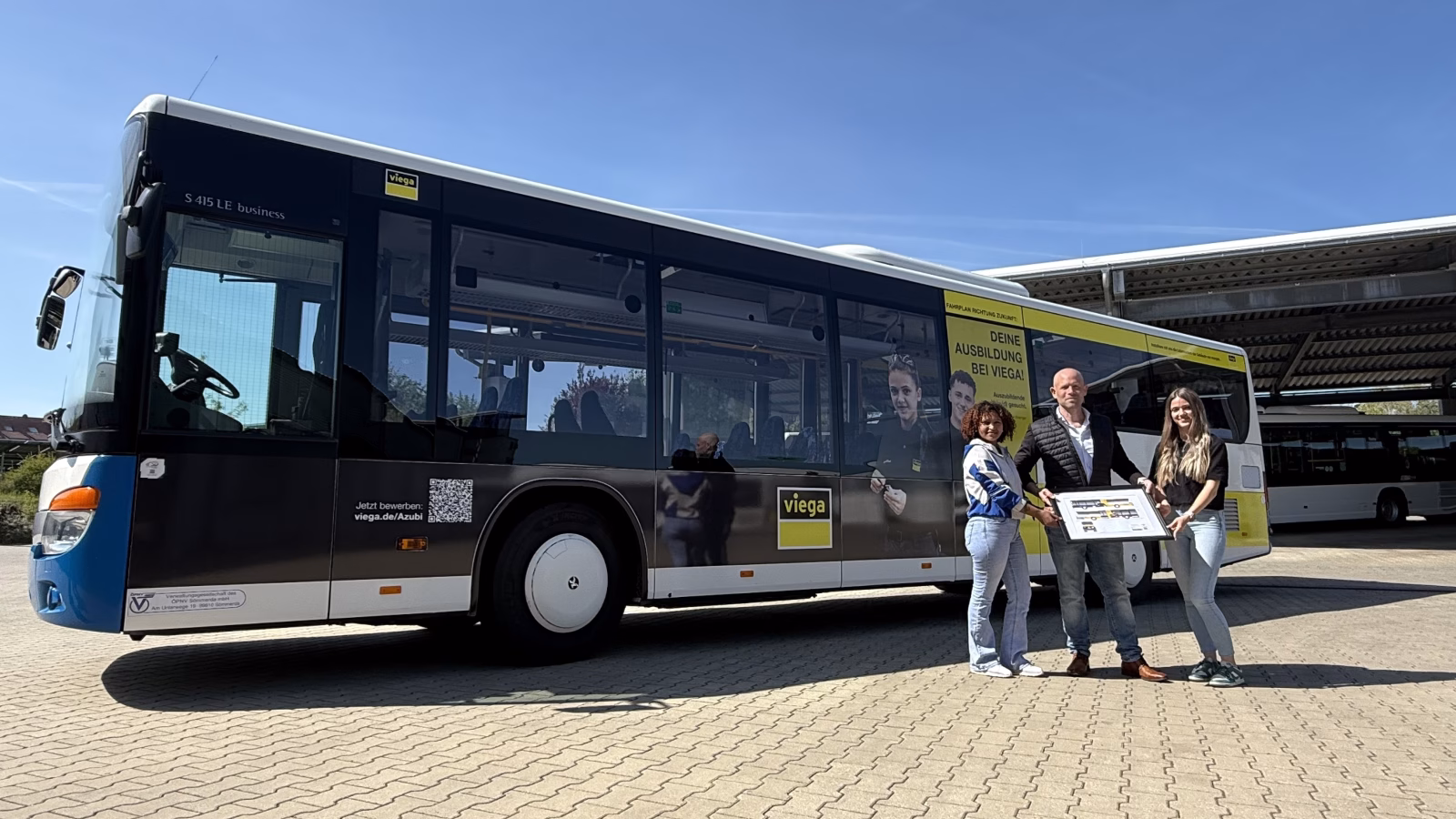 drei Personen stehen vor einem Bus des Unternehmens viega