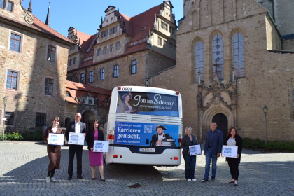 Mehrere Personen stehen vor einem blauen Bus des Saalekreises