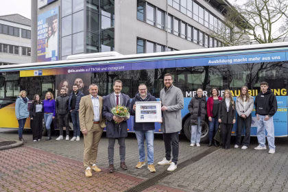 eine Personengruppe stehend vor einem Bus mit IHK Werbung