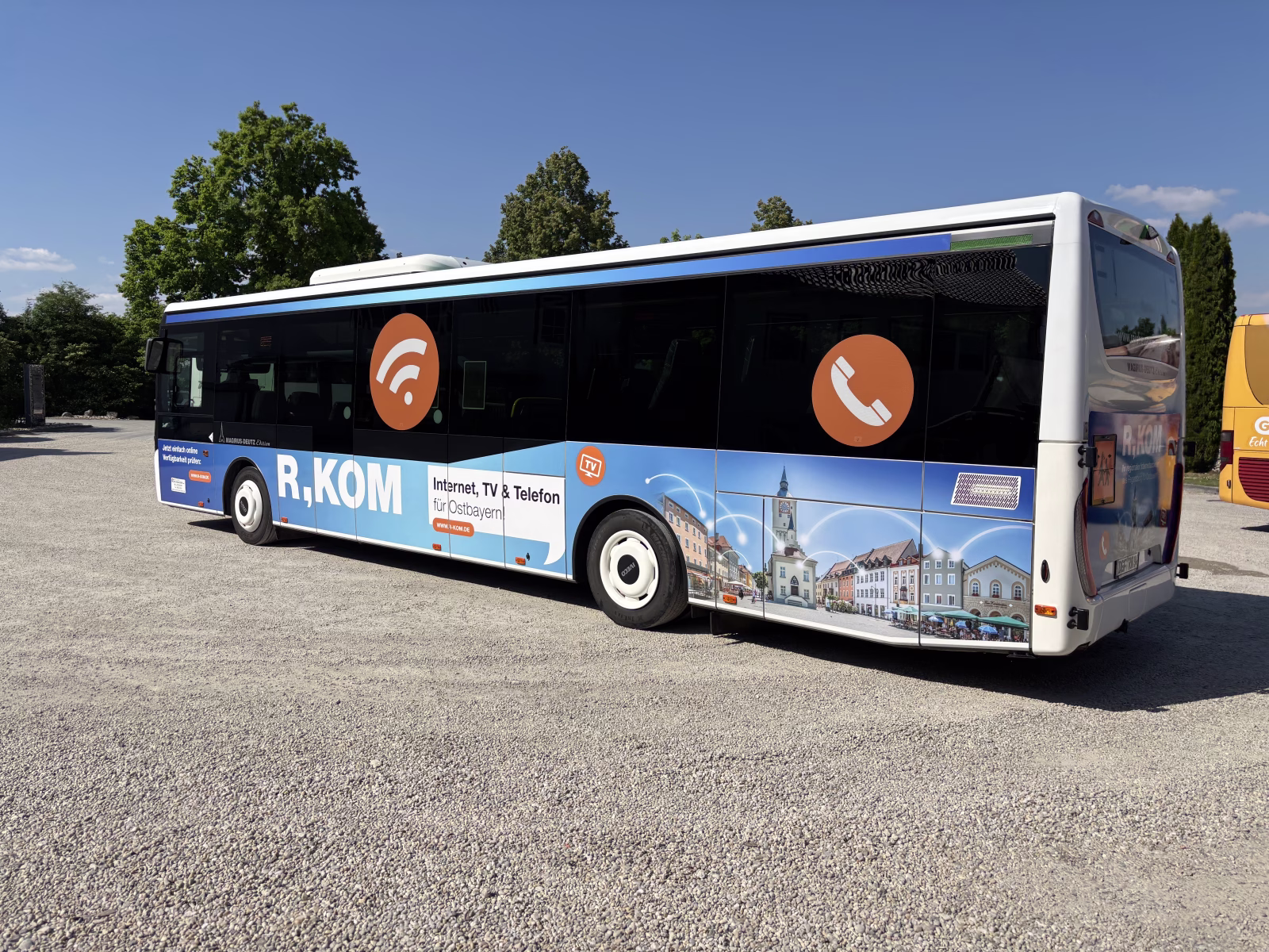 Seitenansicht eines Busses mit Werbung für einen Telefonanbieter