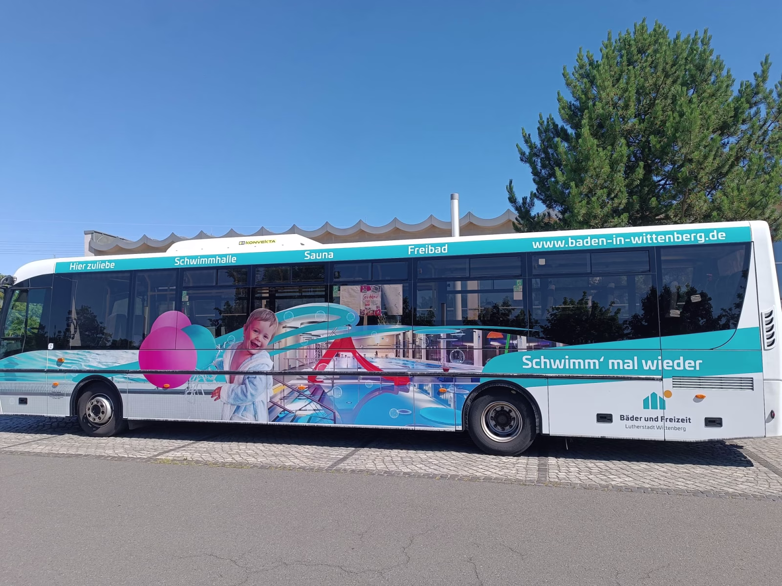 Außenseite eines Busses auf dem Ein Schwimmbad in Wittenberg zu sehen ist