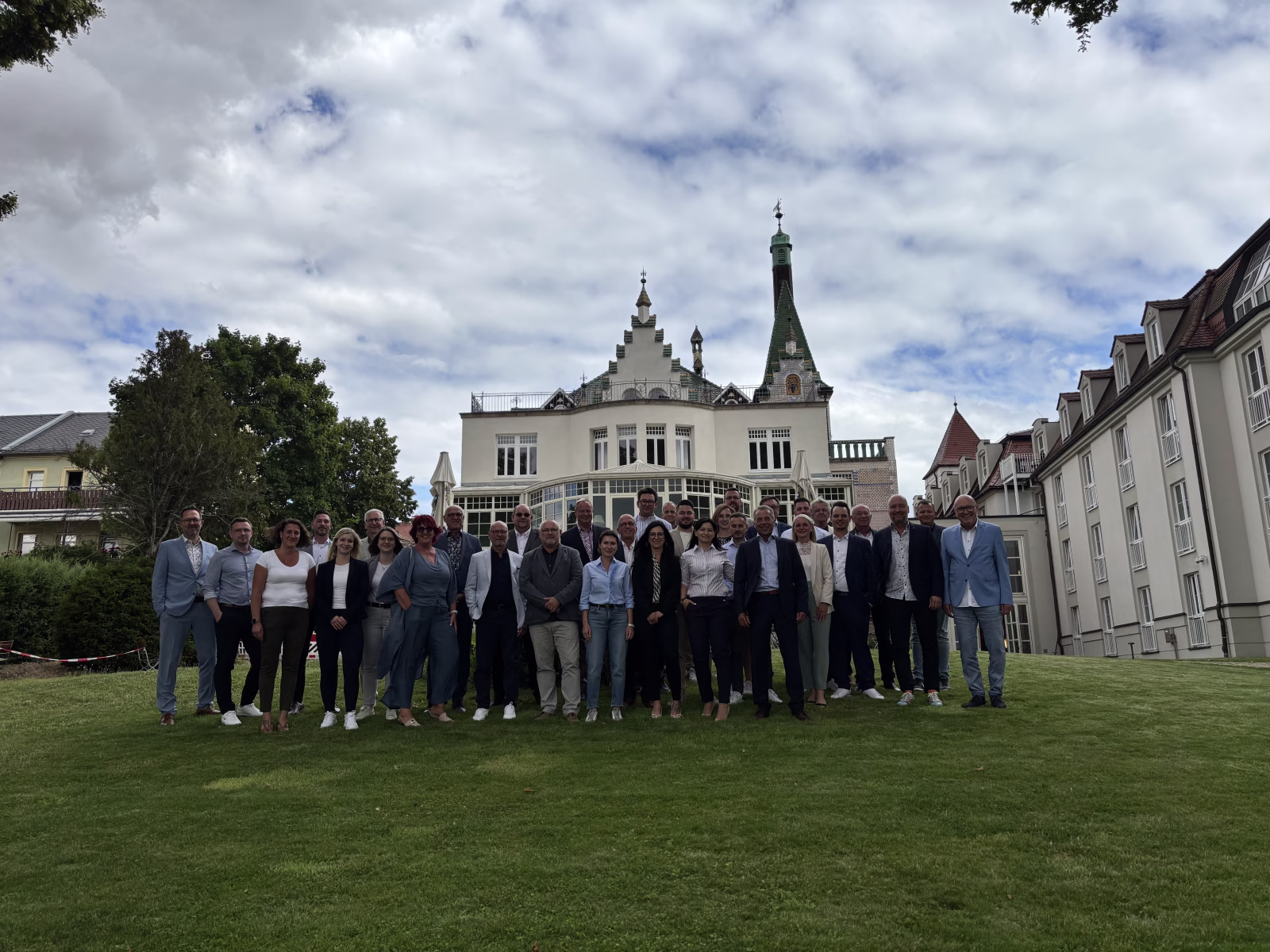 Eine große Gruppe von Menschen steht vor einem Schloss