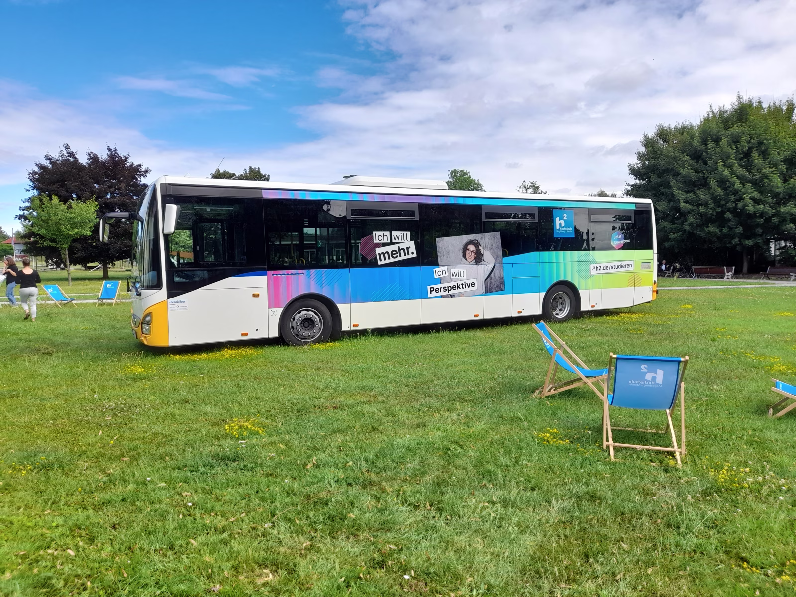 Außenseite eines weißen Bussen mit Ganzwagenwerbung der Hochschule Magdeburg