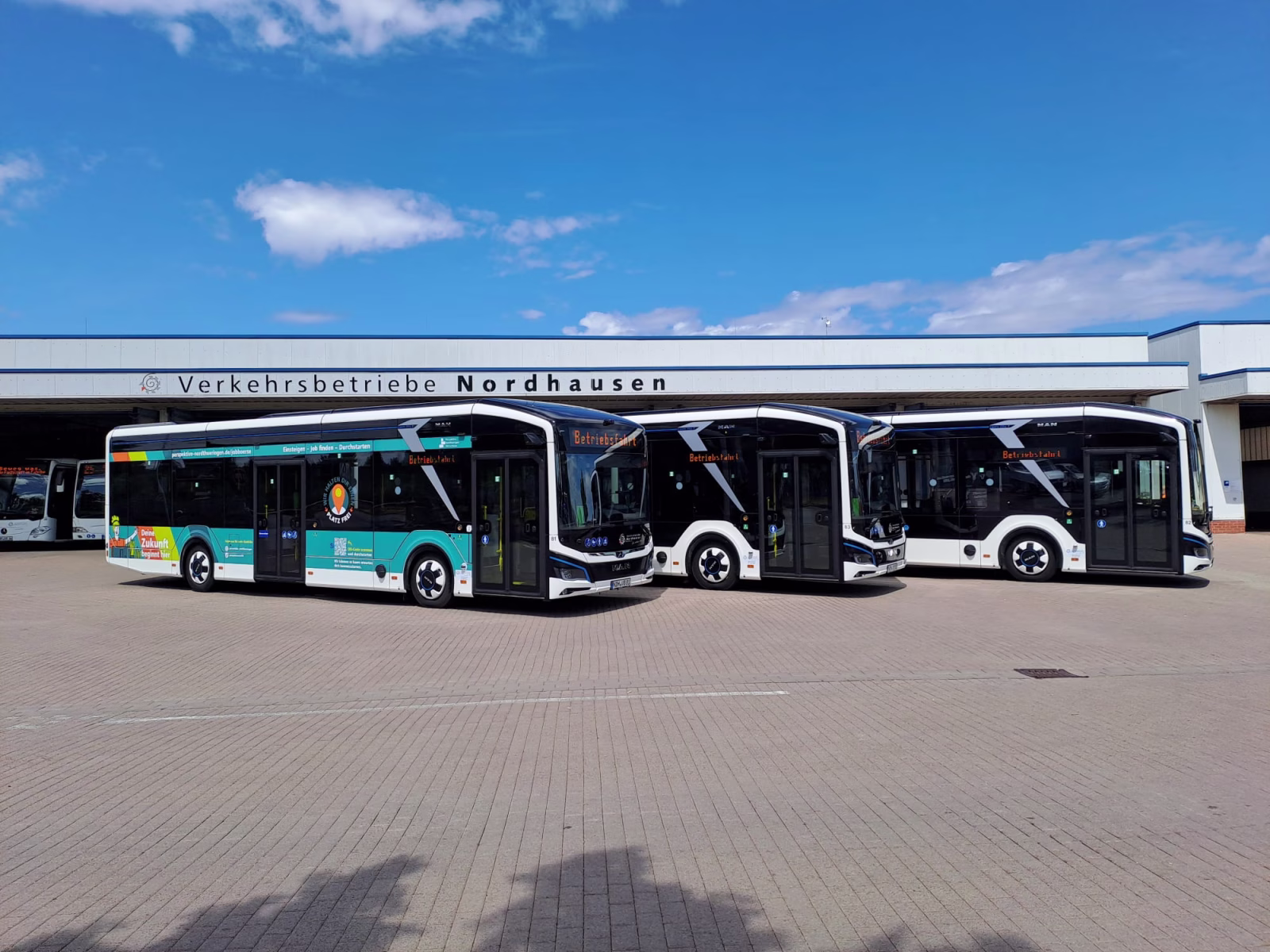 Drei Busse des Regionalmanagement Nordthüringen stehen vor einem Industriegebäude