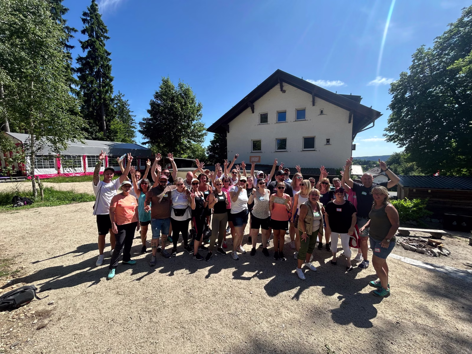 Eine Gruppe von Menschen steht auf einem Berg und jubelt in die Kamera