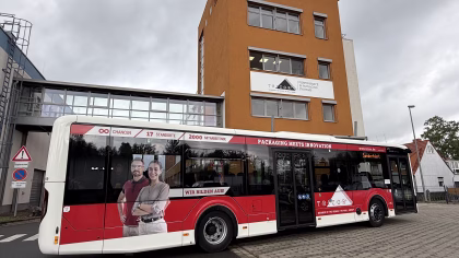 Einstiegsseite eines roten Werbebusses der Firma Tricor