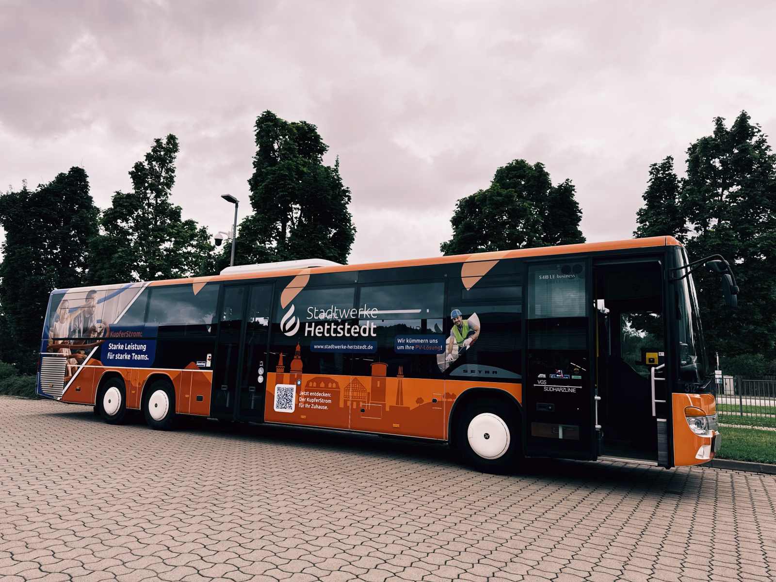 Einstiegsseite eines orangen Werbe-Busses der Stadtwerke Hettstedt