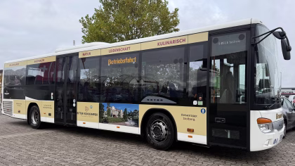 Seitenansicht der Einstiegsseite eines Werbebusses der Hotelanlage Kempski