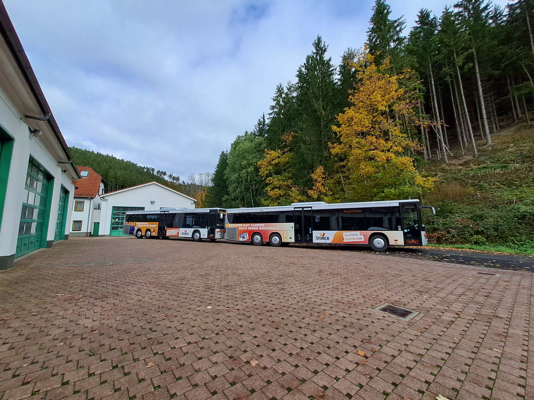 zwei Busse der Firma Storck stehen auf einem Betriebshof