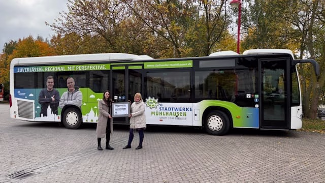 Zwei Personen stehen vor einem und präsentieren eine Grafik dessen