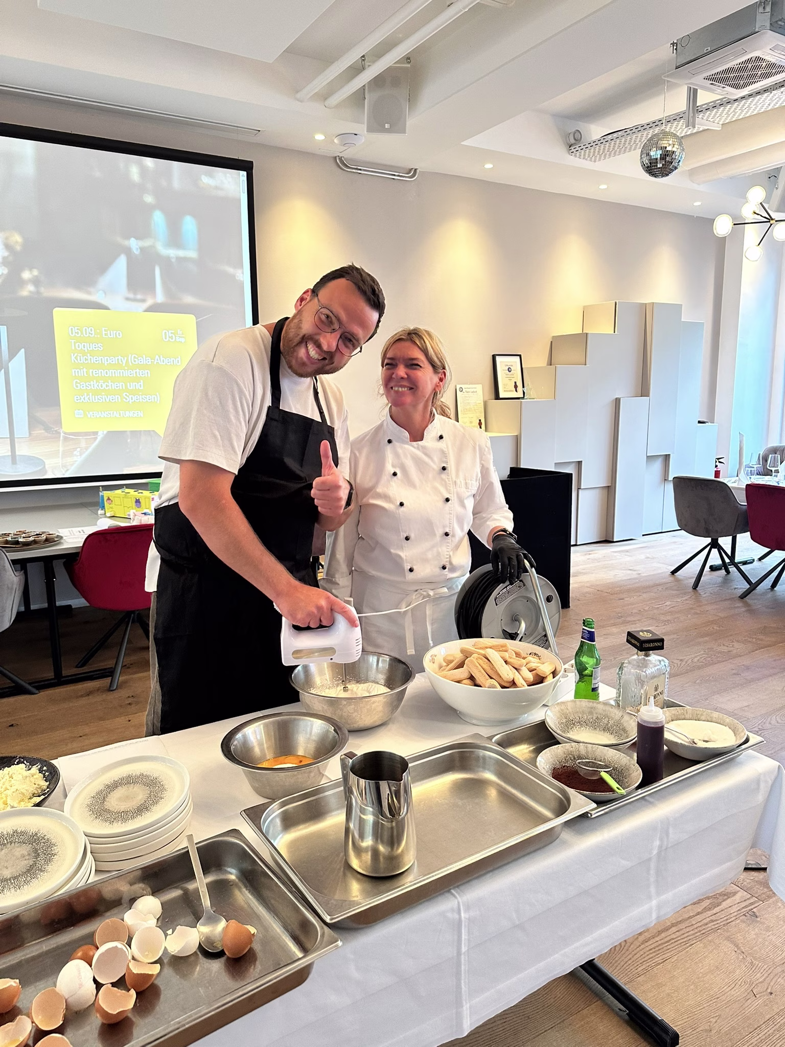 Zwei Personen stehen vor einer Küchenzeile und kochen