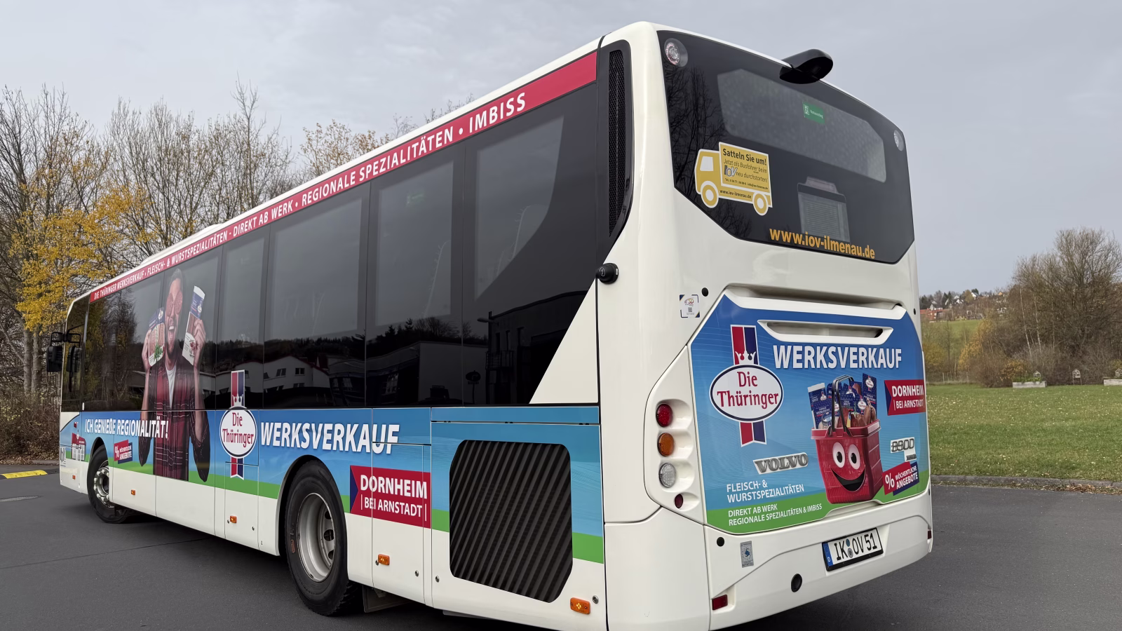 Heckaufname eines weißen Busses mit Werbung der Firma "Die Thüringer"