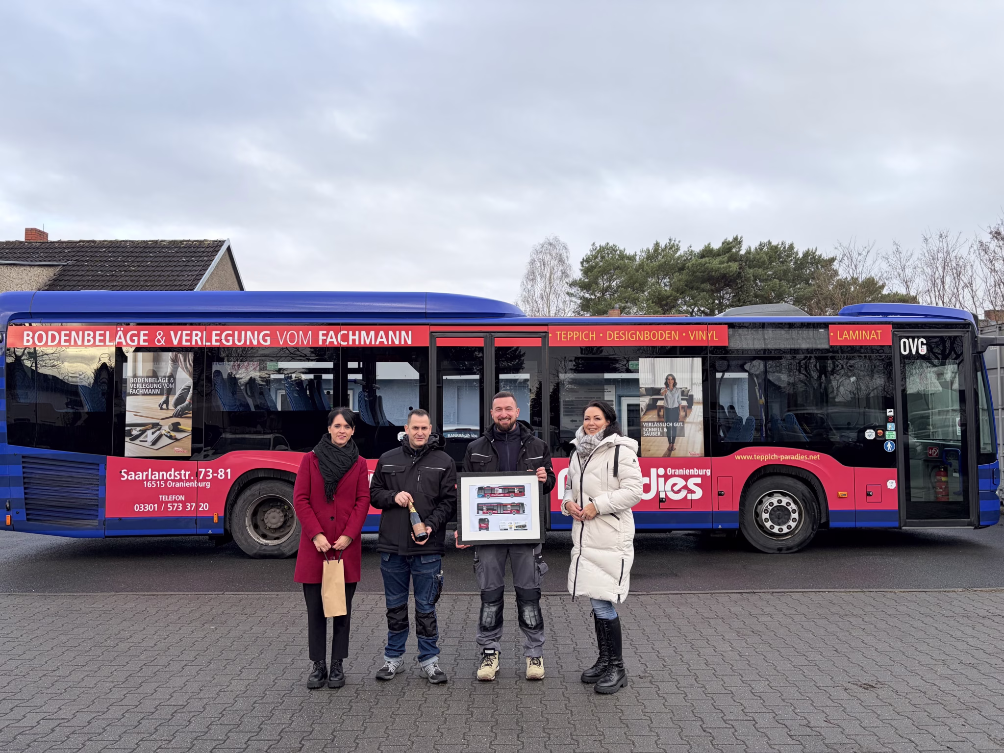 vier Personen stehen vor einem Werbebus der Firma TeppichParadies