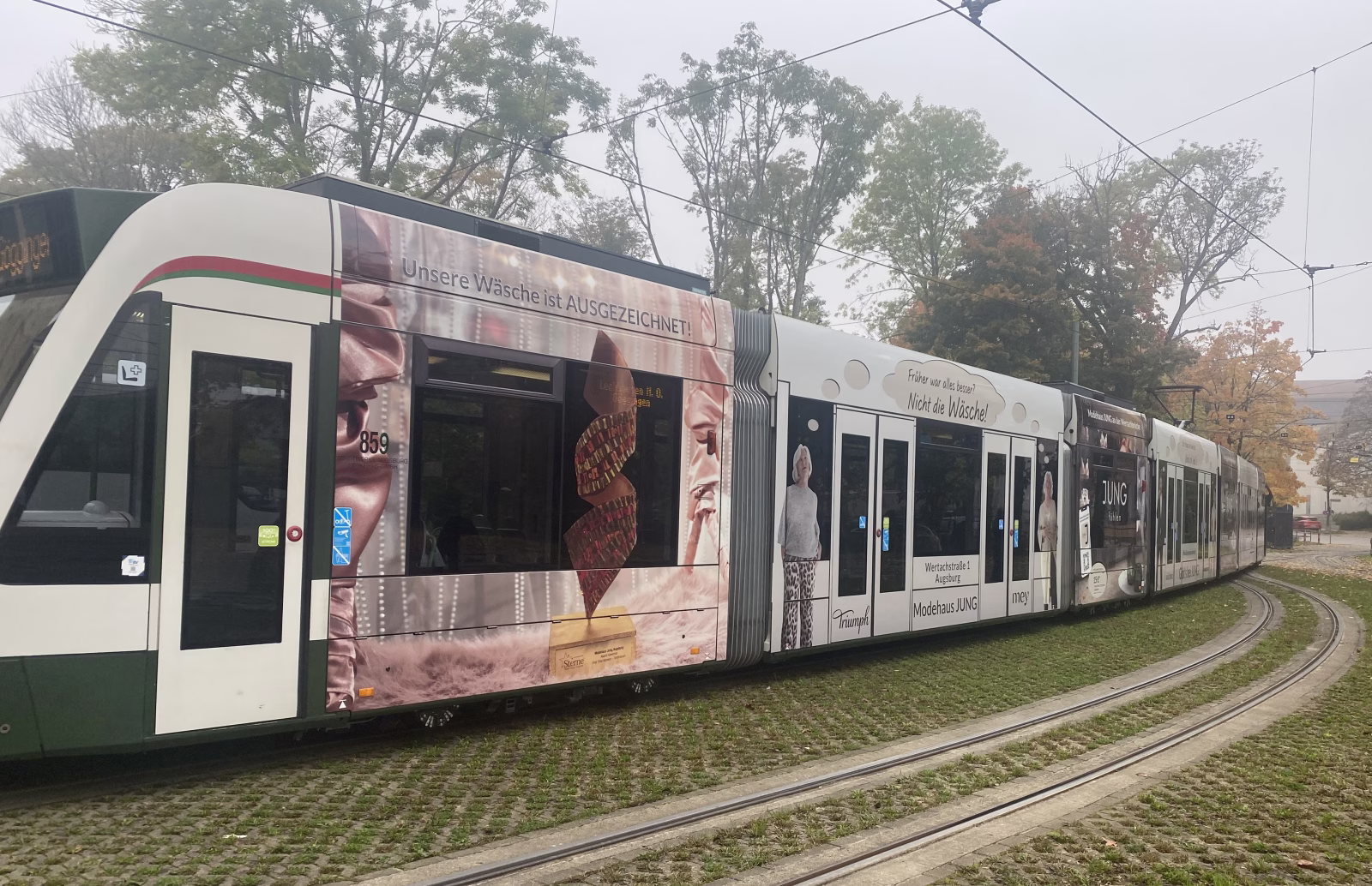 Seitenansicht einer Straßenbahn mit Werbung des Modehaus Jung