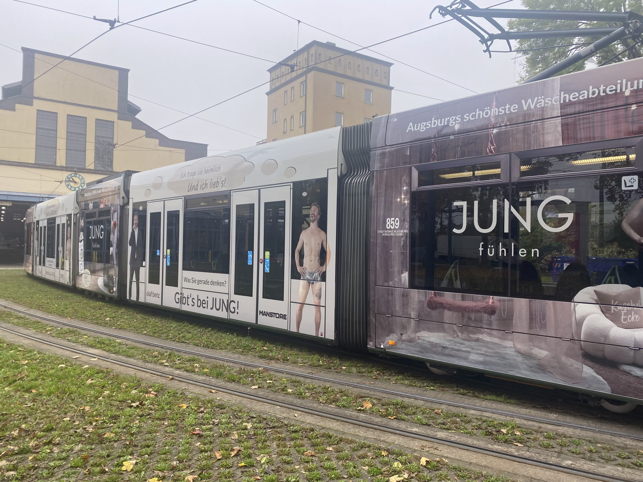 Seitenansicht einer Straßenbahn mit Werbung vom Modehaus Jung