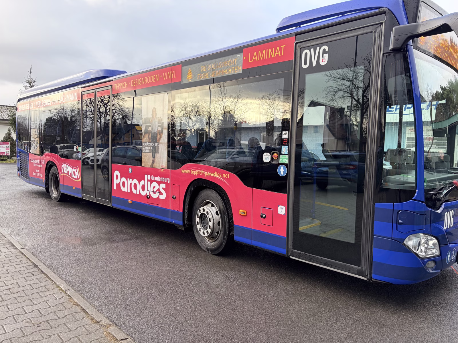 Einstiegsseite eines Busses mit Werbung des Teppich Paradies