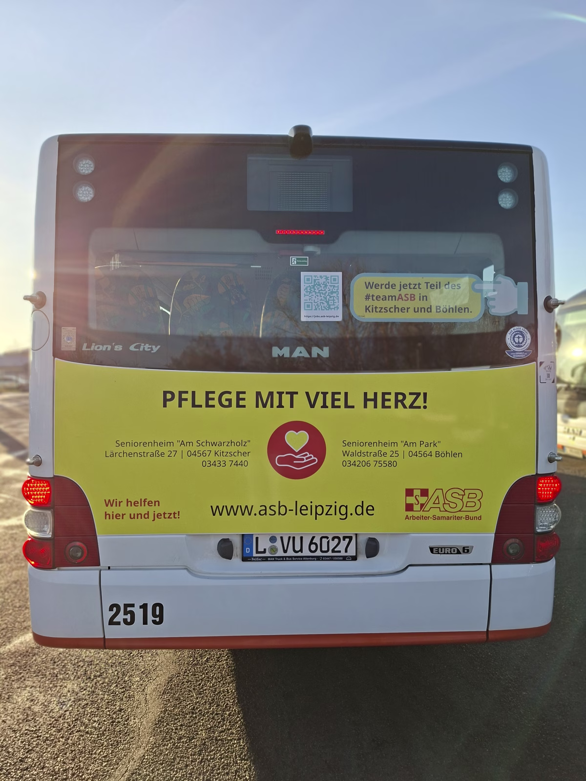 Heckansicht eines gelben Werbebusses der ASB