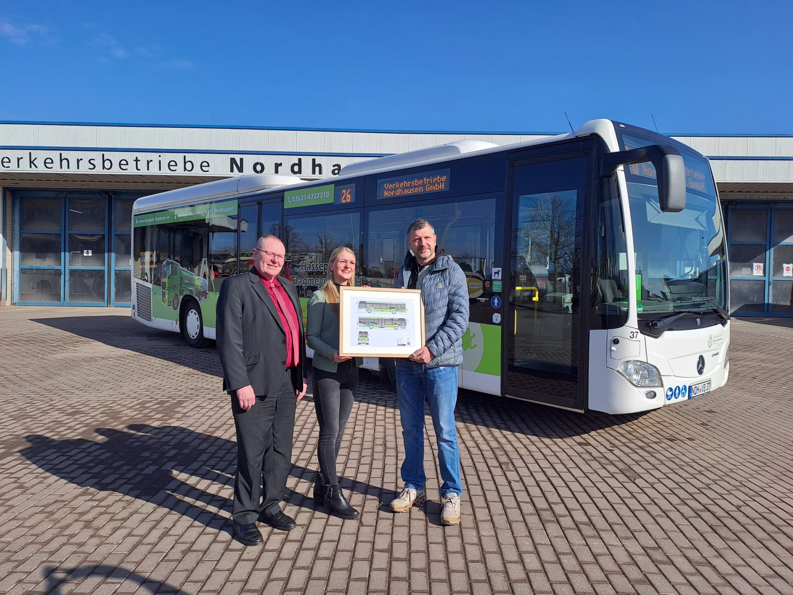 Drei Personen stehen vor einem Bus der Firma Hassepass&Flagmeyer