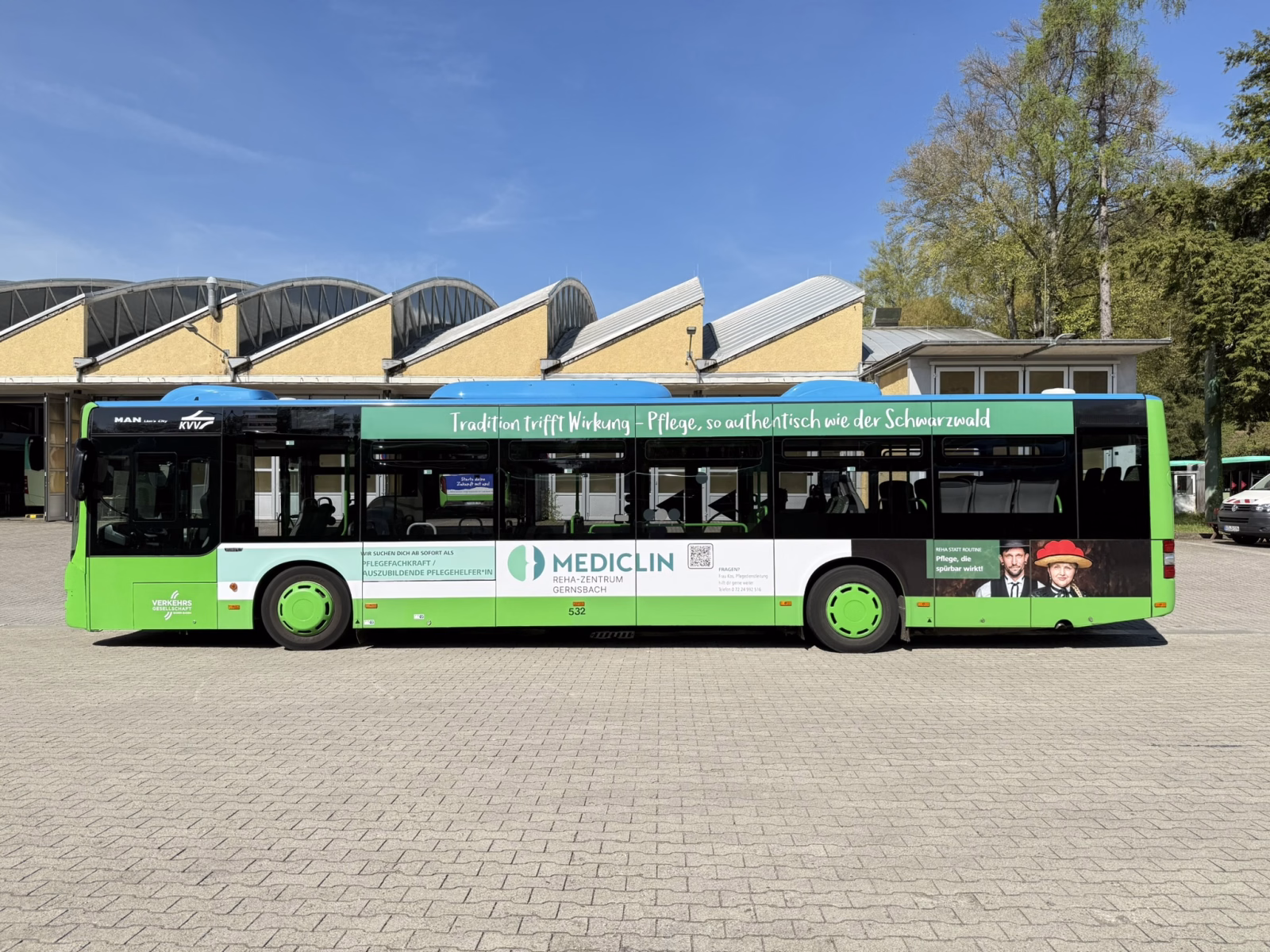Außenseite eines grünen Werbebusses mit einer Ganzwagenwerbung von mediclin gernsbach