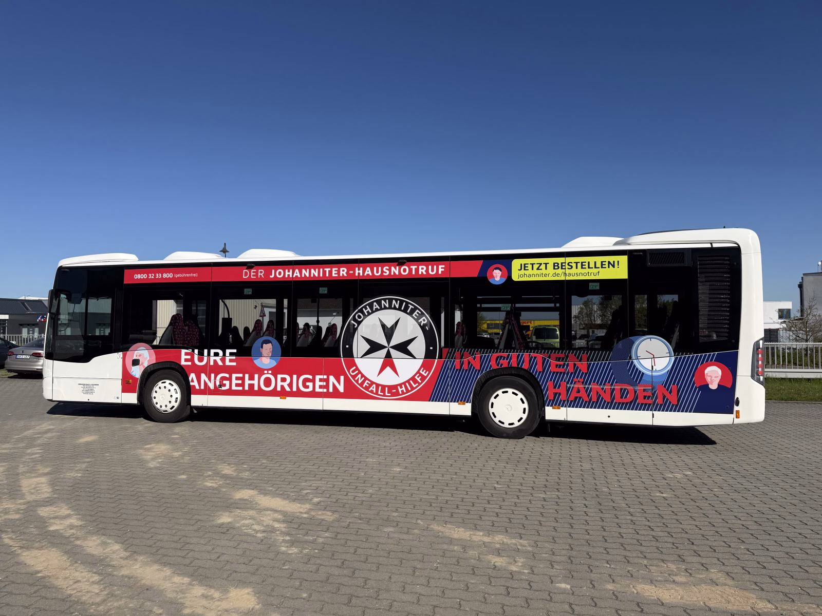 Seitenansicht eines weißen Busses mit Werbung der Johanniter Thüringen