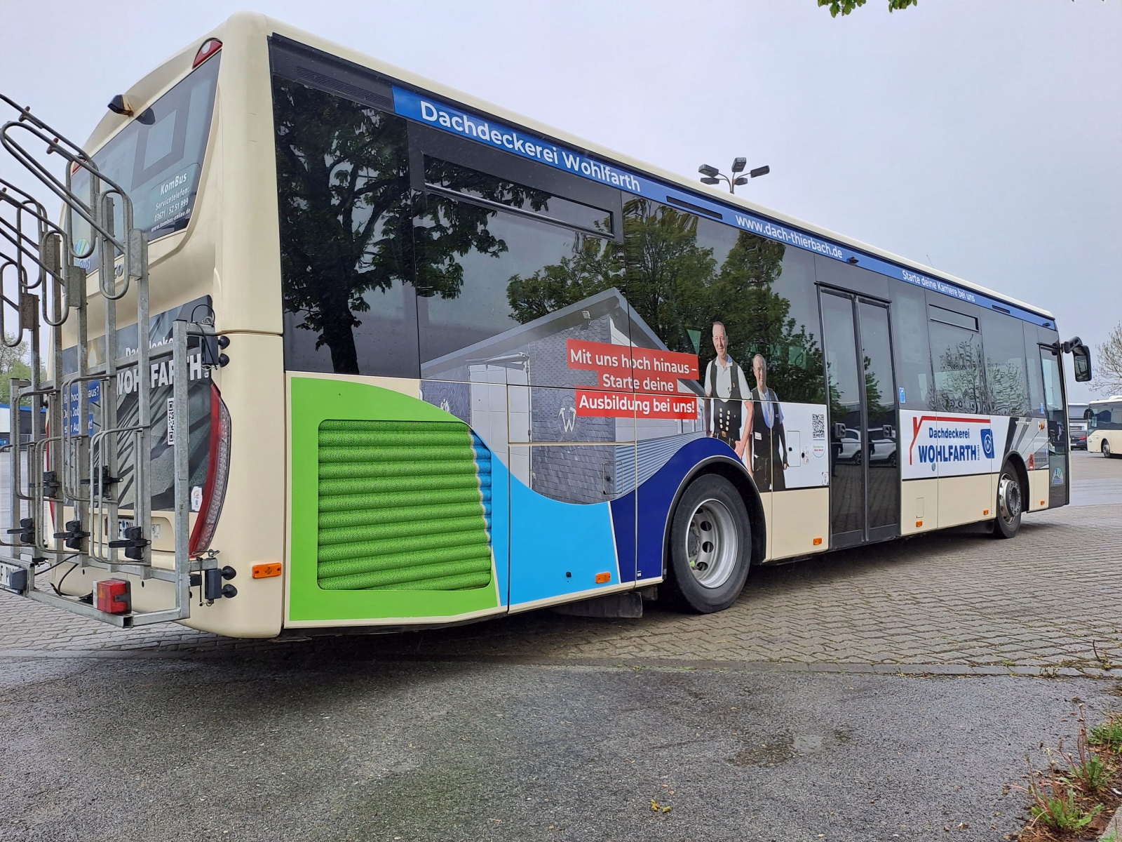 Einstiegsseite eines beigen Werbebusses der Dachdeckerei Wohlfahrt