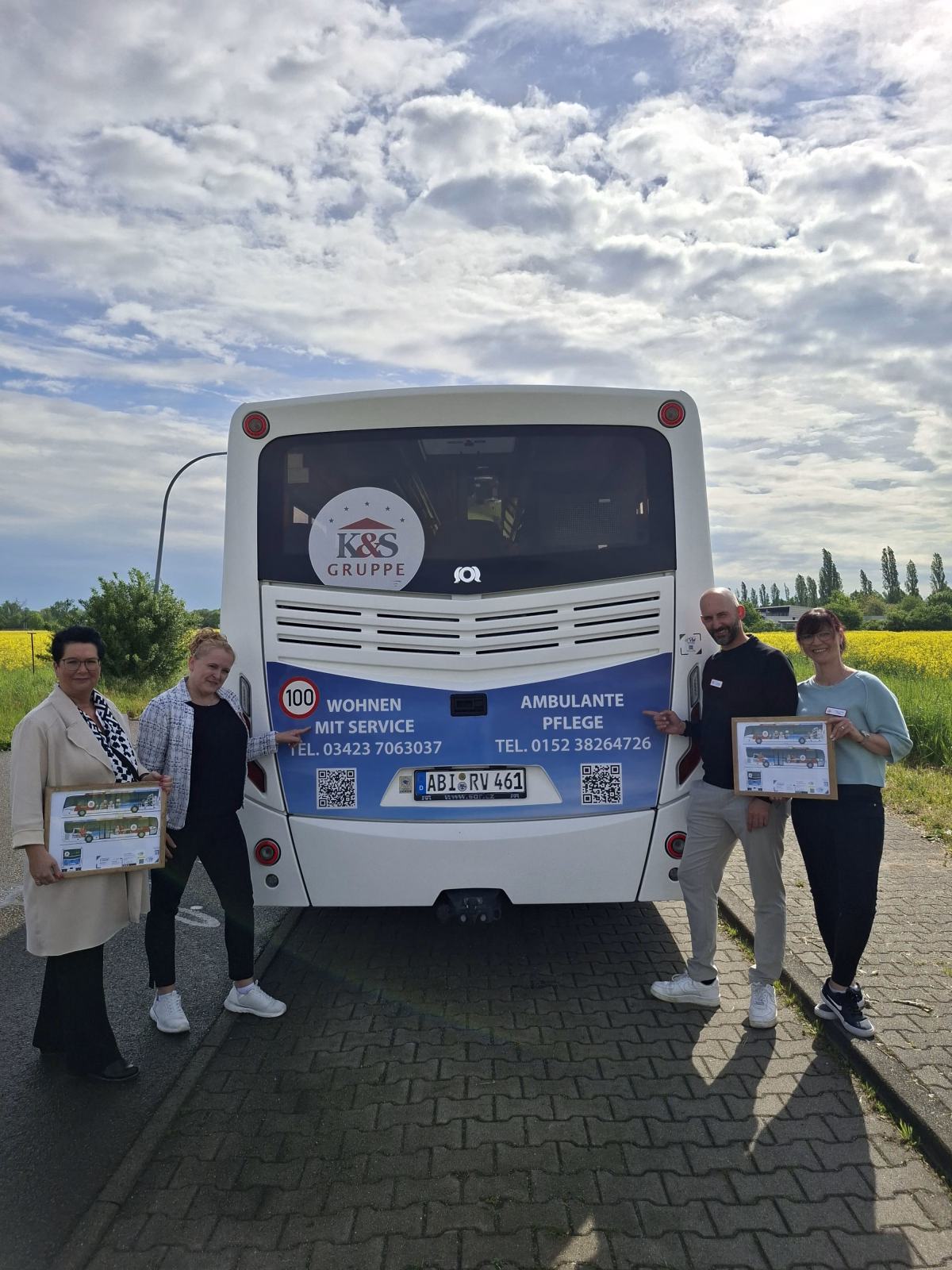 4 Personen stehen vor dem Heck eines Busses mit Werbung der K&S Seniorenresidenz Eilenburg
