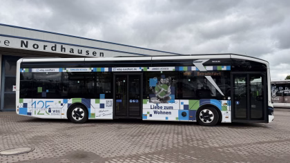 Seitenansicht eines weißen Werbebusses, der auf einem Betriebshof steht mit Werbung der WBG Südharz