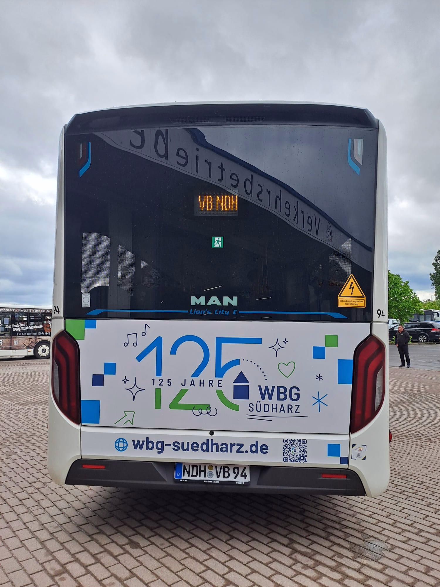 Heckansicht eines weißen Werbebusses mit Werbung der WBG Südharz