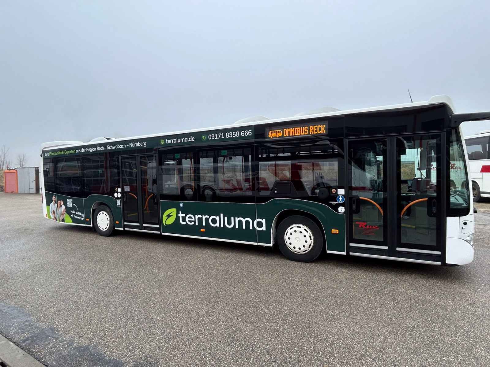 Einstiegsseite eines dunklen Busses mit Werbung der terraluma GmbH