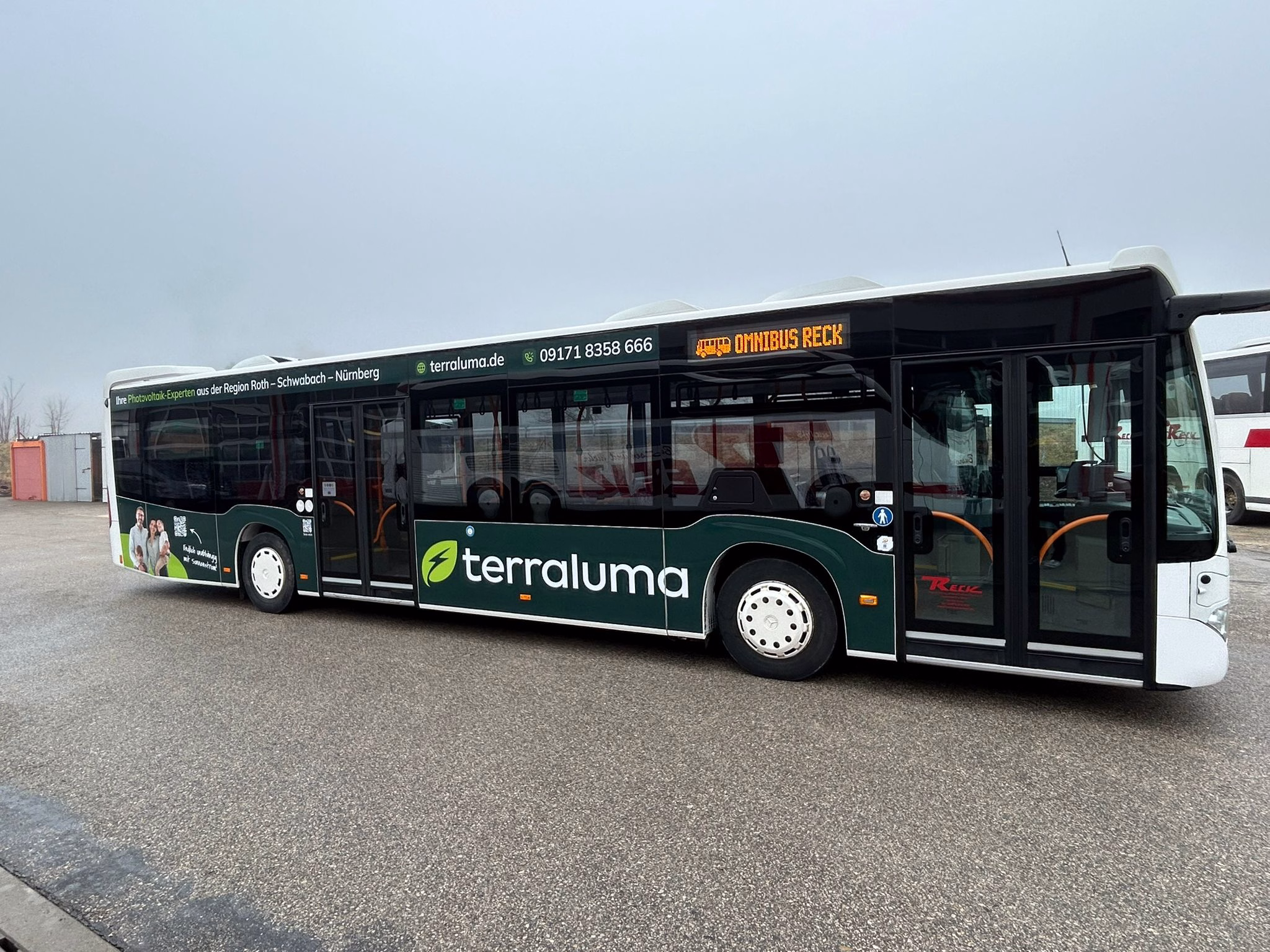 Einstiegsseite eines dunklen Busses mit Werbung der terraluma GmbH