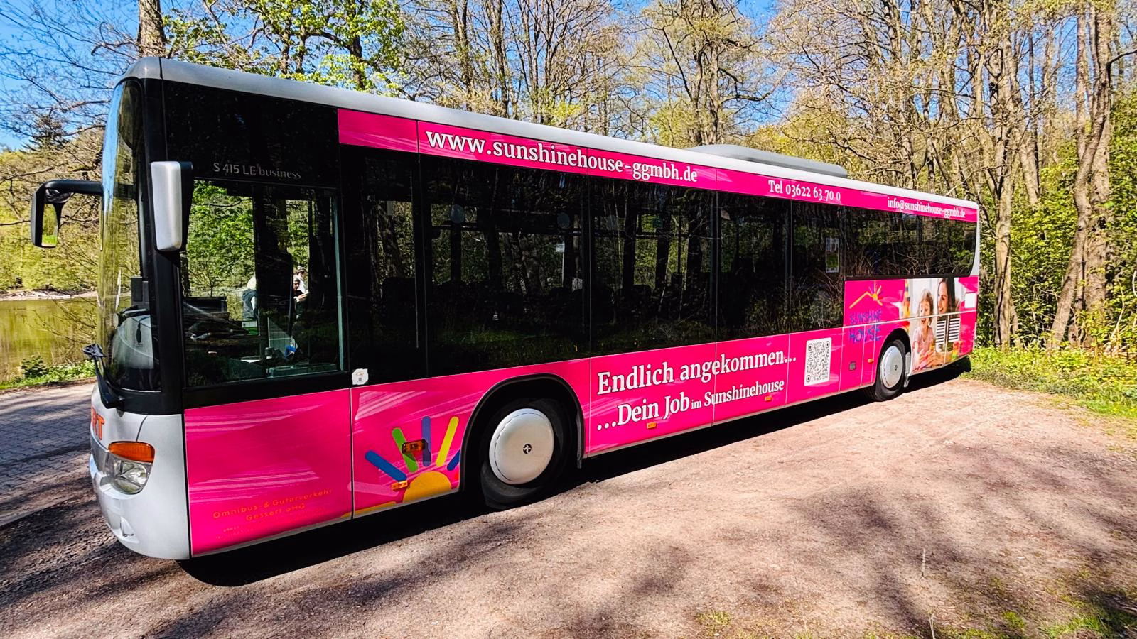Außenaufnahme eines pinken Werbebusses mit Werbung des sunshinehouses
