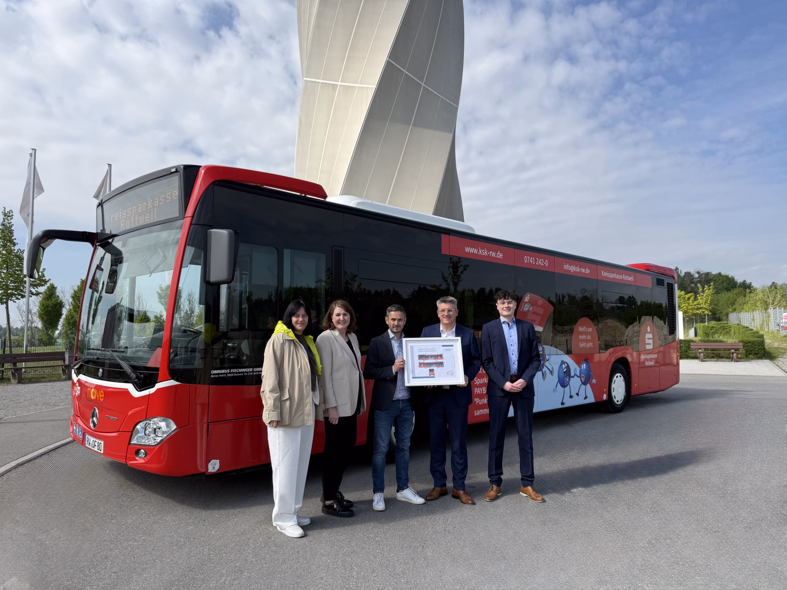 Fünf Personen stehen vor einem Bus mit Werbung der Sparkasse Rottweil