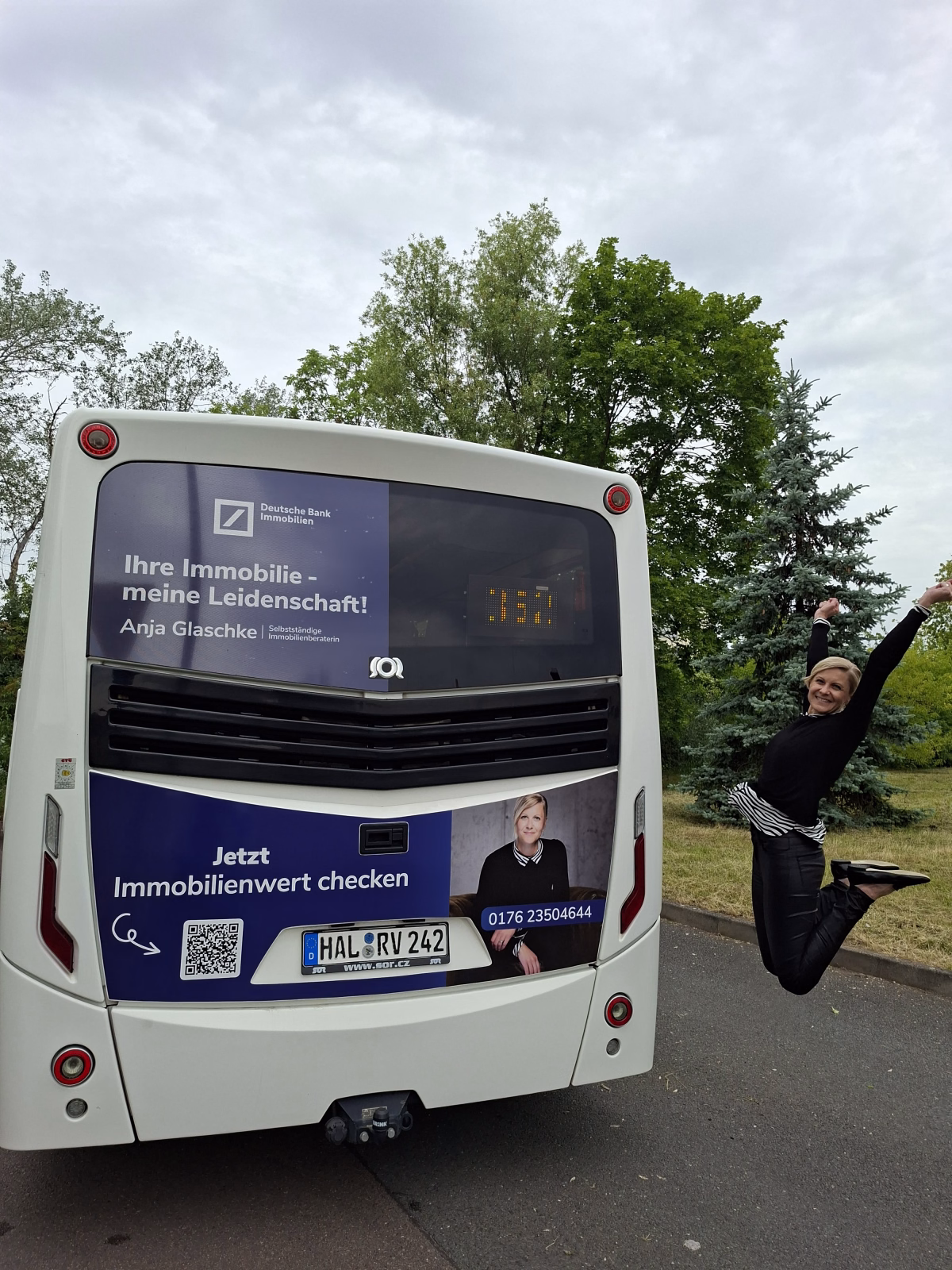 Eine Frau springt neben einem weißen Bus