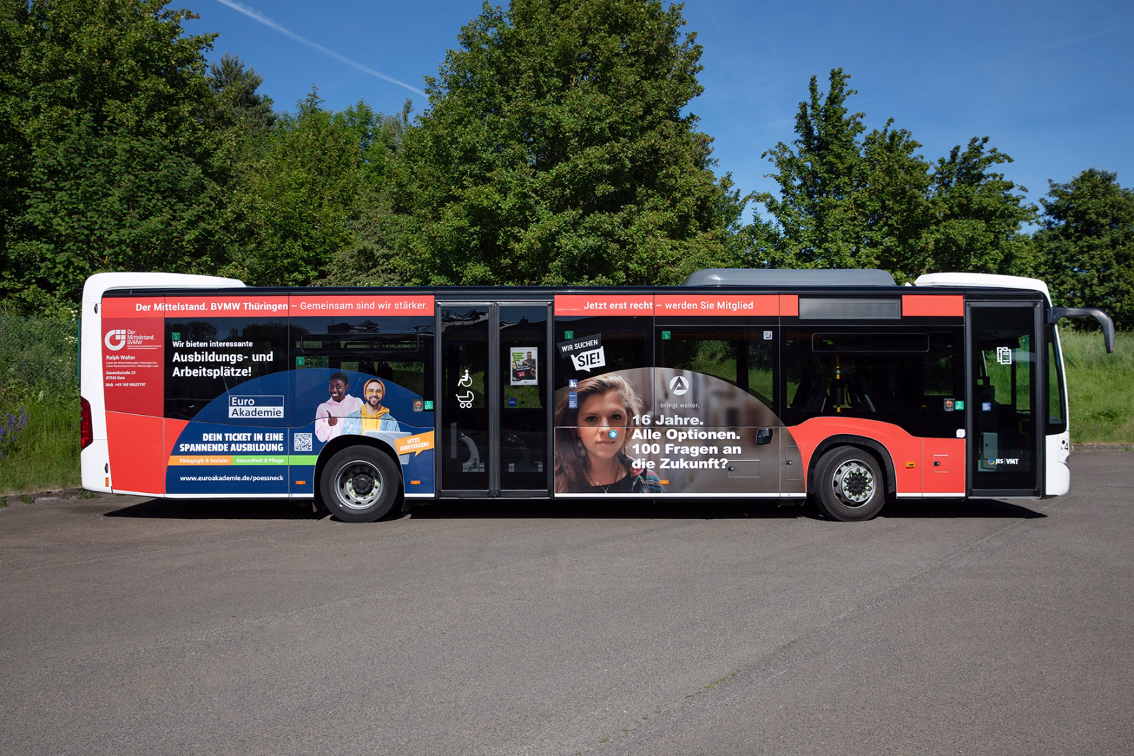 Seitenansicht eines roten Werbebusses mit Werbung der Kingspan