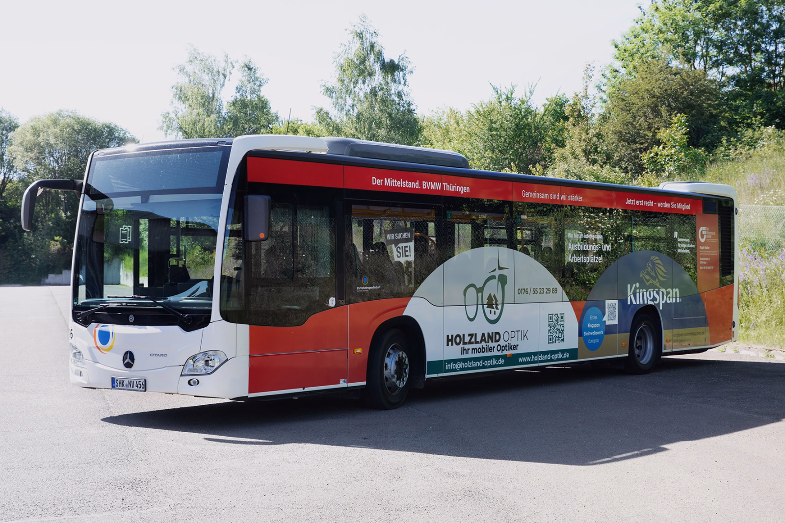 Außenansicht eines roten Stadtbusses mit Werbung unterschiedlicher Unternehmen der BVMW Thüringen