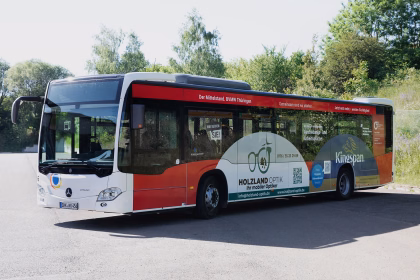 Außenansicht eines roten Stadtbusses mit Werbung unterschiedlicher Unternehmen der BVMW Thüringen