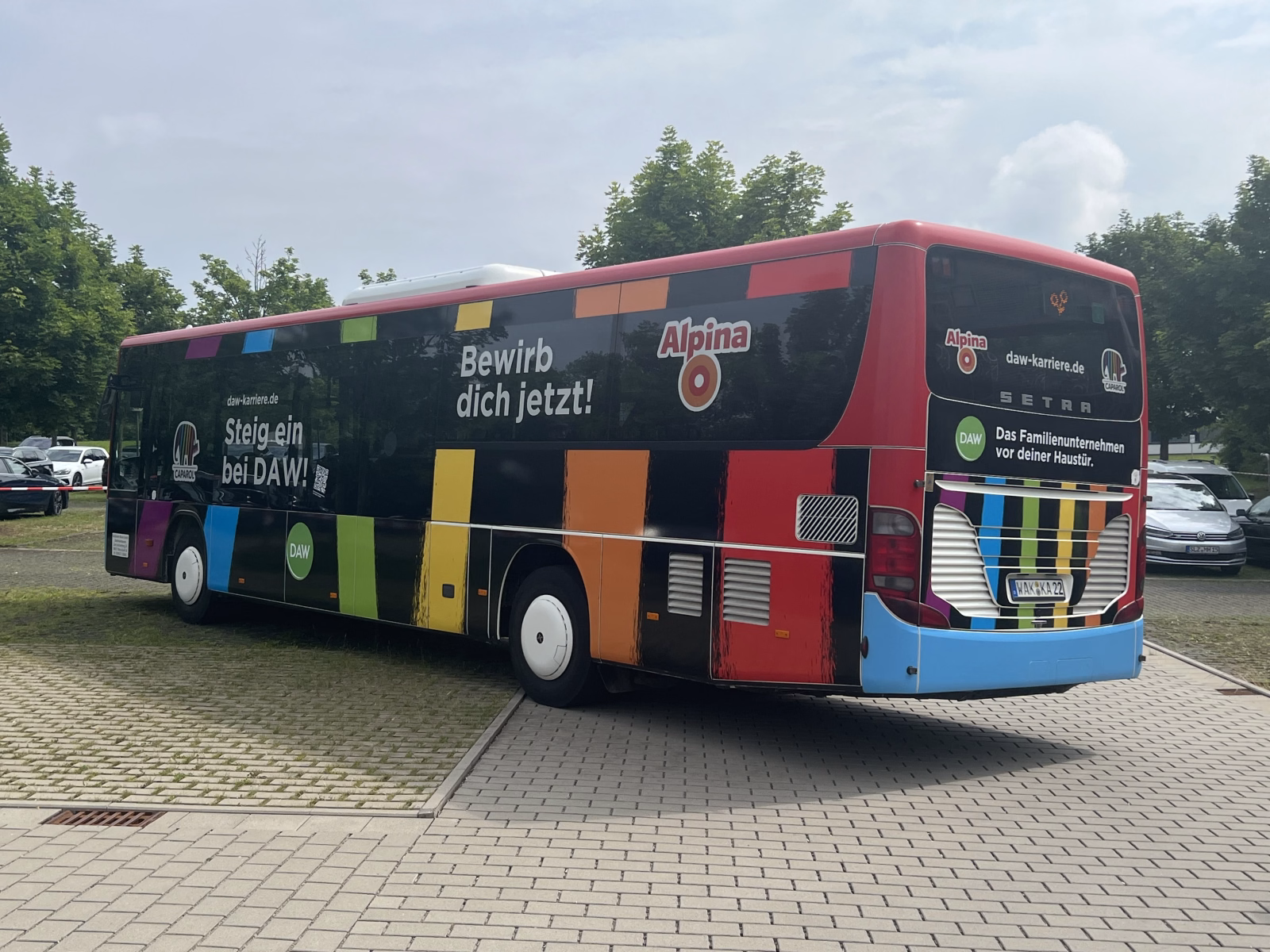 Außenansicht eines bunten Stadtbusses mit Werbung der DAW Gruppe
