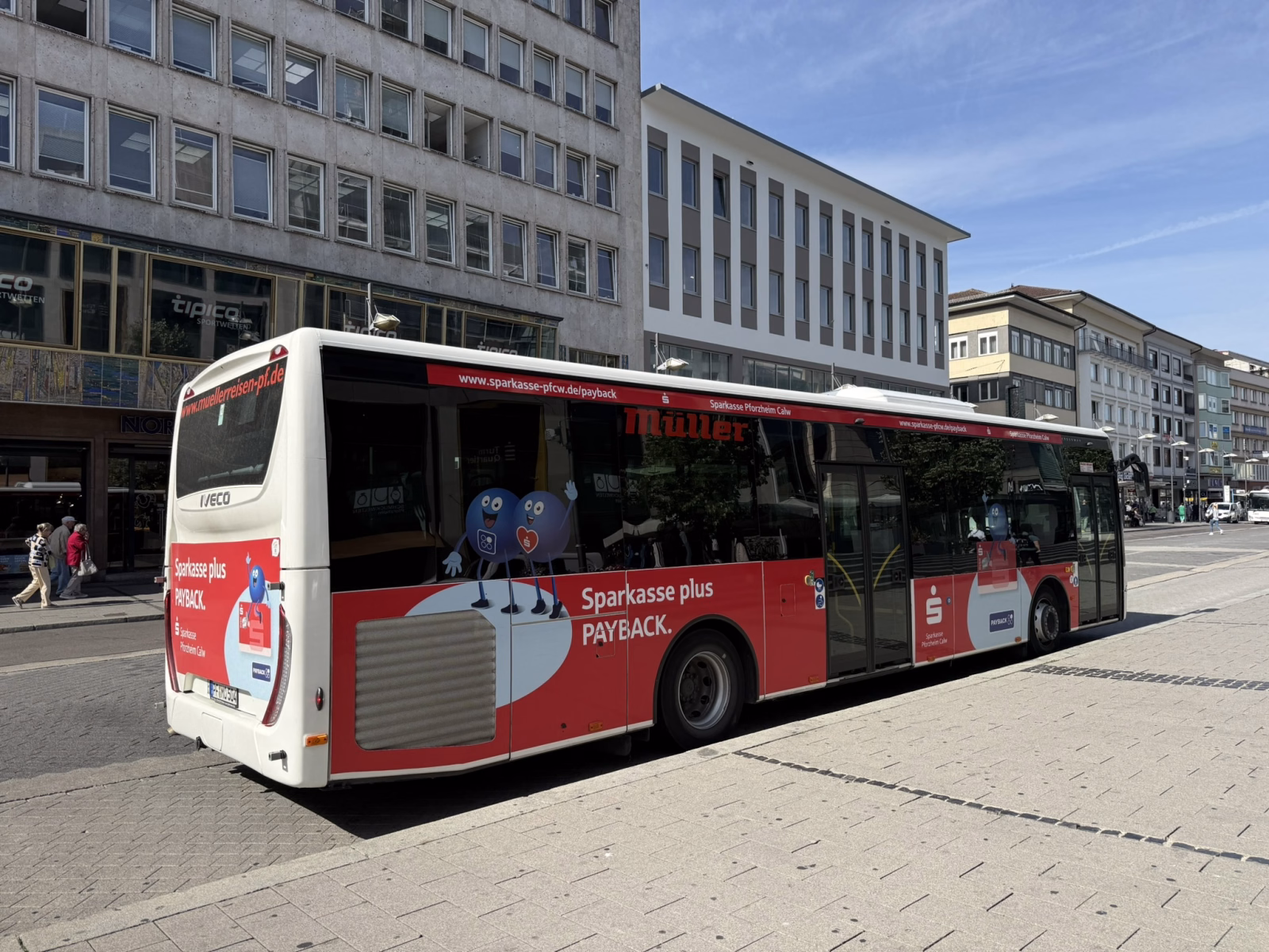 Einstiegsseite eines rot, weißen Busses mit Werbung der Sparkasse Pforzheim