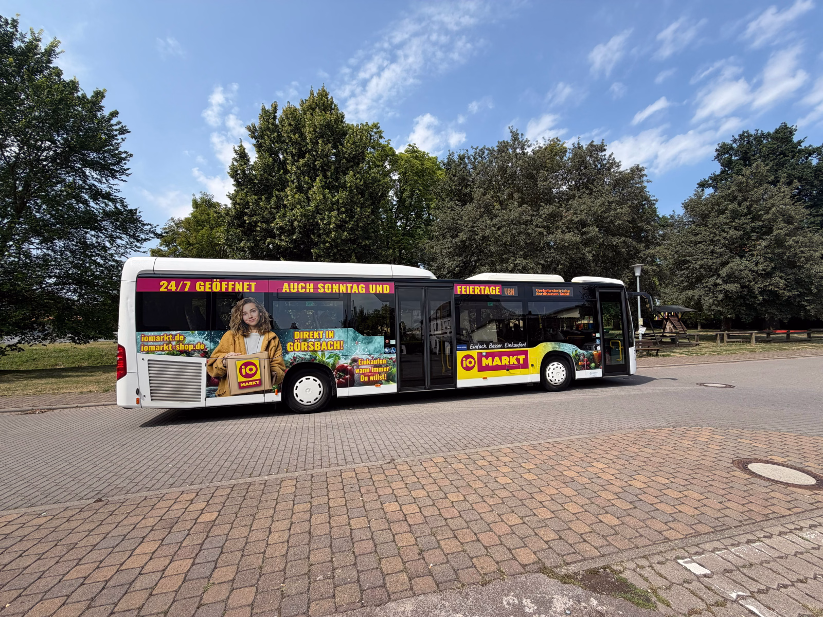 Einstiegsseite eines Stadtbusses mit Werbung des io Marktes