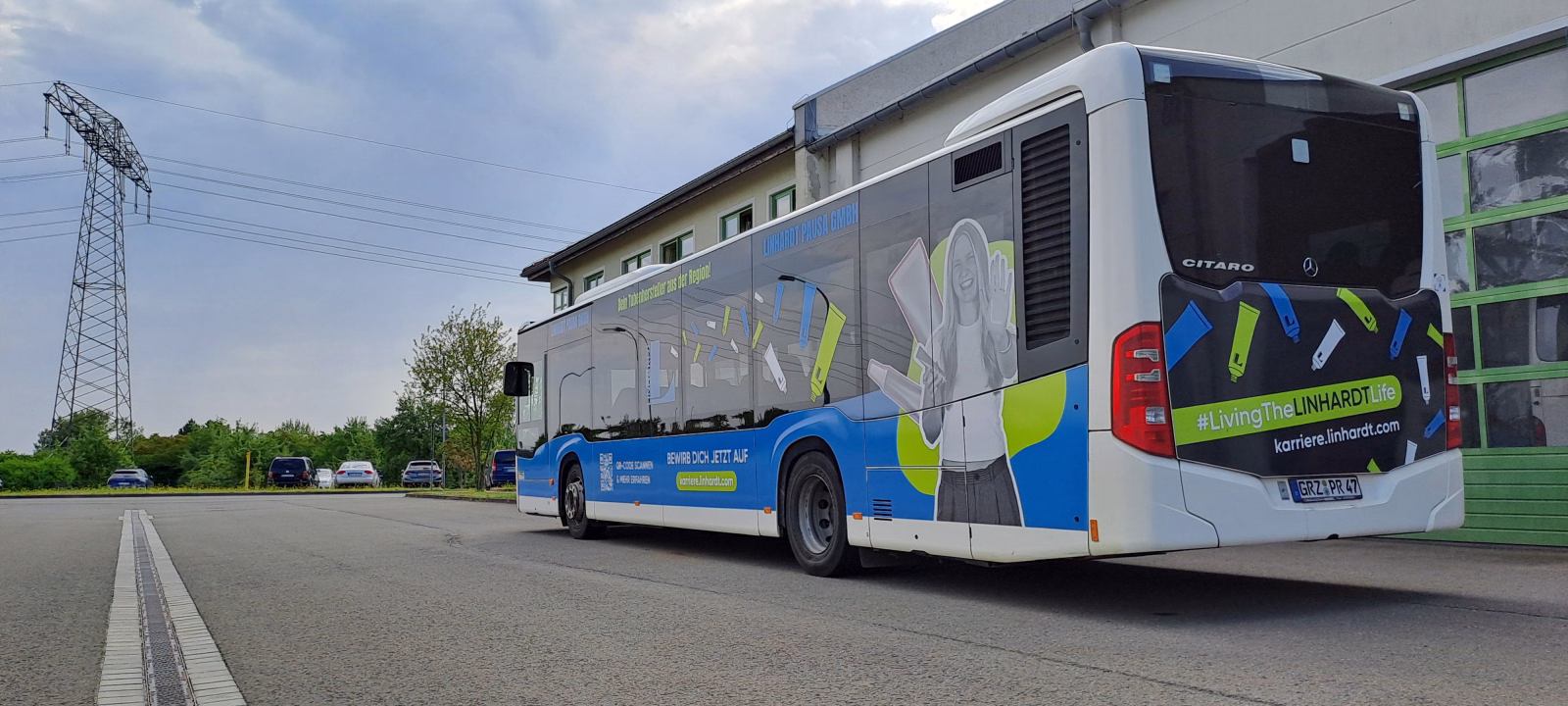 Außenseite und Heckansicht eines blauen Werbebusses mit WErbung der Linhard GmbH