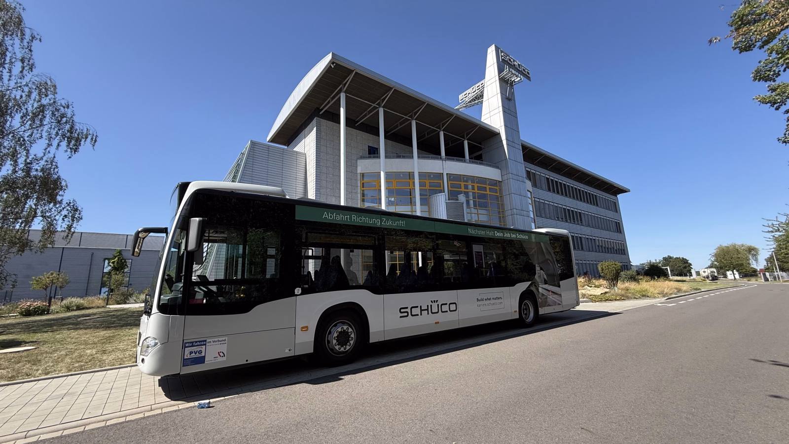Außenansicht eines weißen Werbebusses mit Werbung von Schüco Polymer