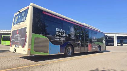Einstiegsseite eines beigen Werbebusses mit Werbung von Matthäs Küchen