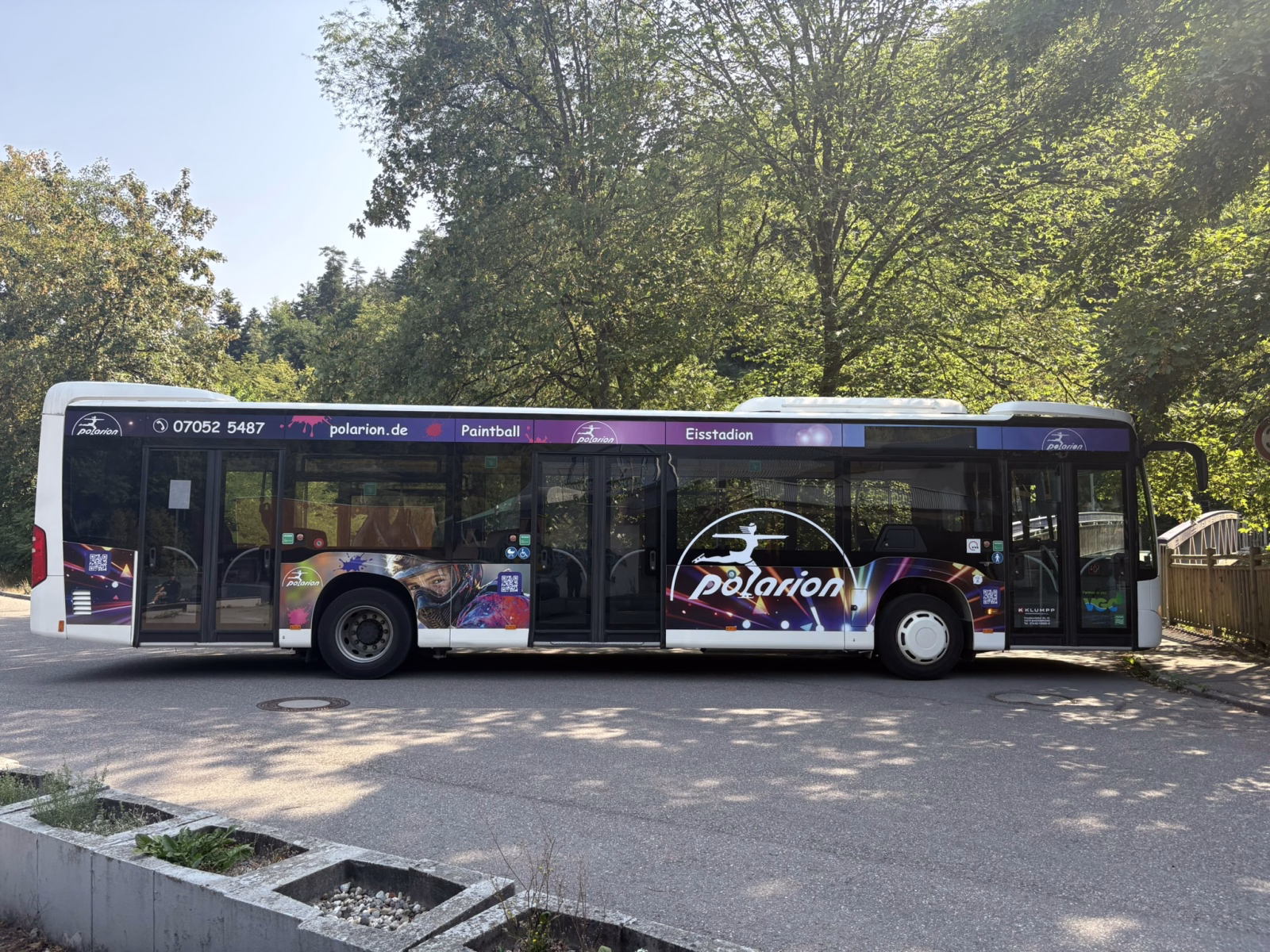 Einstiegsseite eines blauen Busses mit Werbung von Klöbo Escape