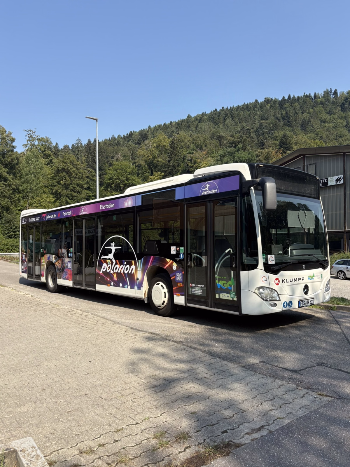 Frontansicht eines weißen Werbebusses mit Werbung des Kölbo Escape