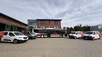 Betriebshof mit einem Werbebus und Firmenfahrzeugen des Garant Personalservices