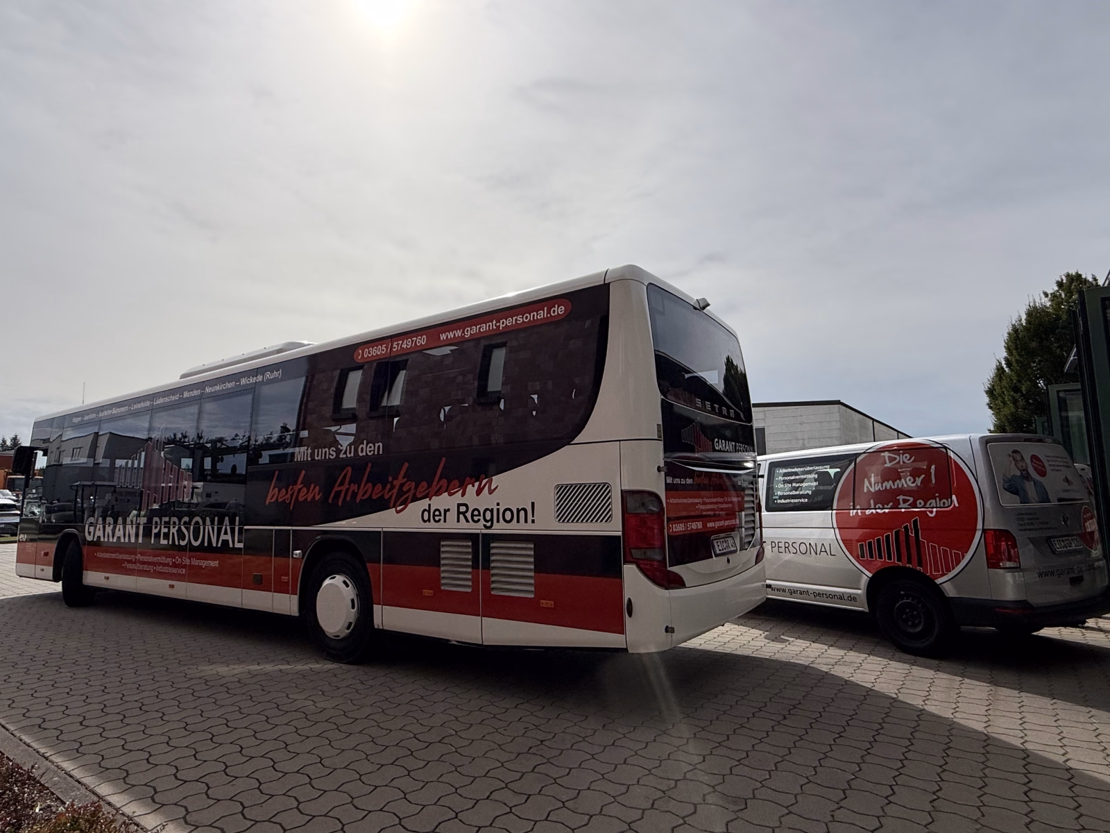 Außenseite eines weißen Werbebusses mit Werbung des Garant Personalservices