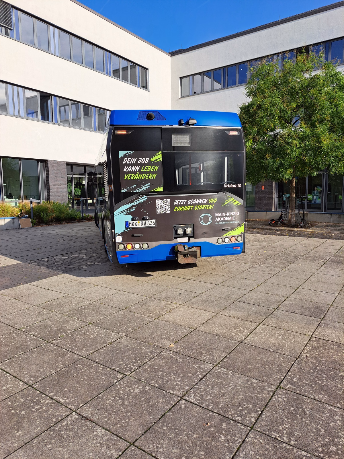 Heckansicht eines blauen Werbebusses der Main-Kinzig-Akademie